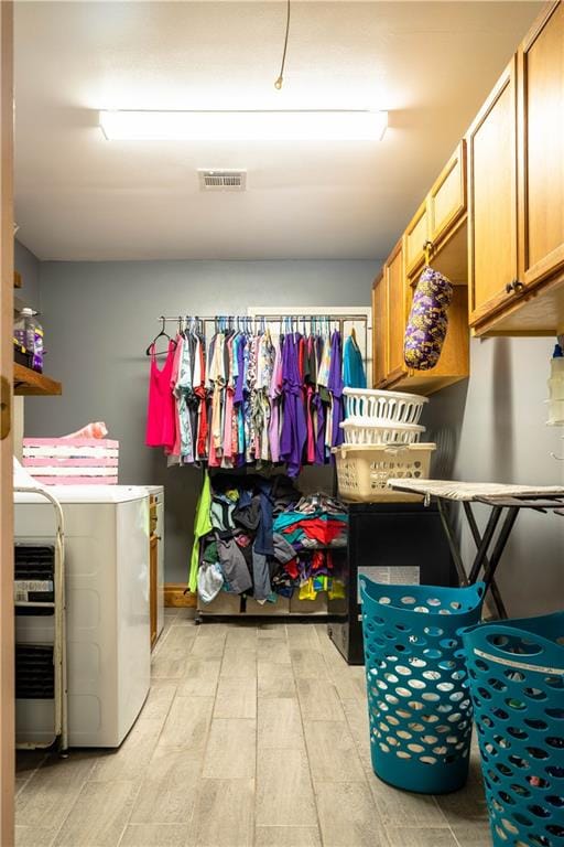 laundry area with washer and clothes dryer and cabinets