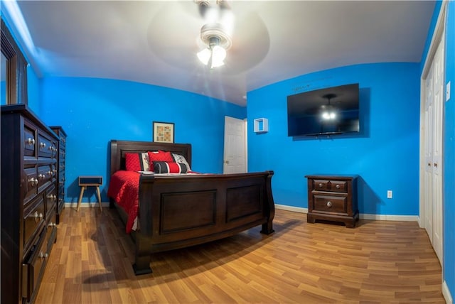 bedroom with ceiling fan, a closet, and wood-type flooring