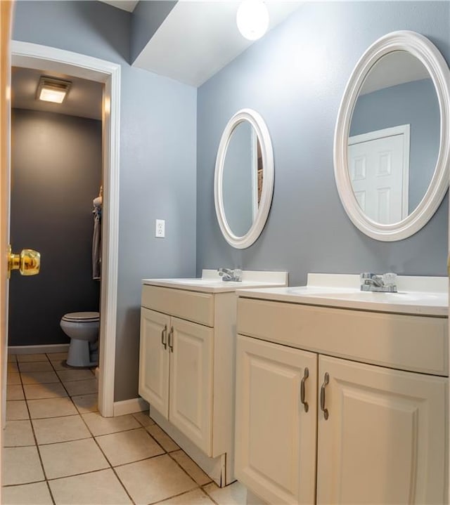 bathroom featuring toilet, dual bowl vanity, and tile patterned flooring