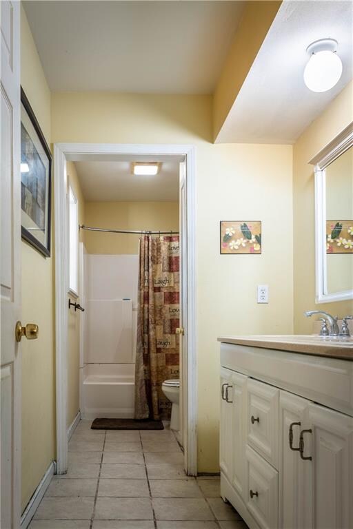 full bathroom featuring shower / tub combo, vanity, toilet, and tile patterned flooring