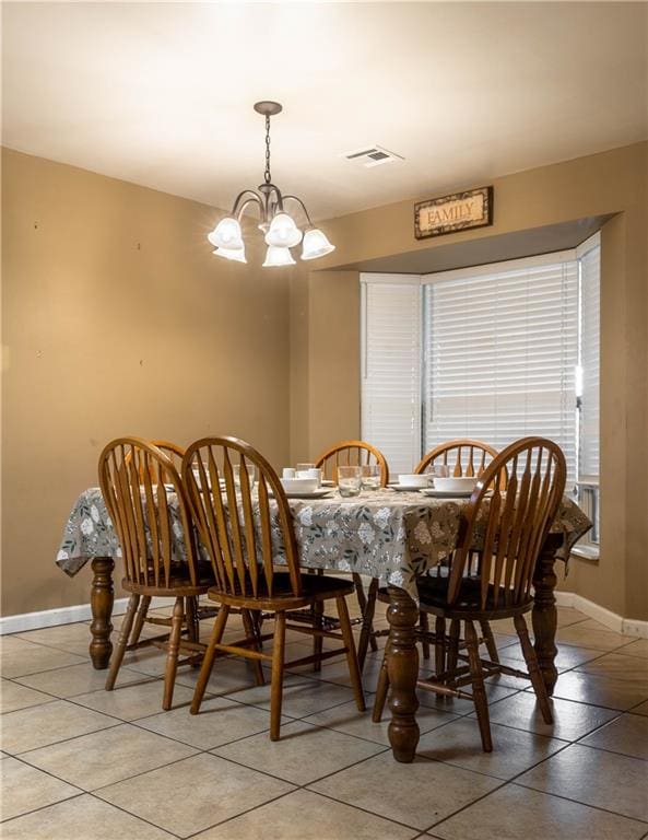 dining area featuring light tile patterned floors and an inviting chandelier