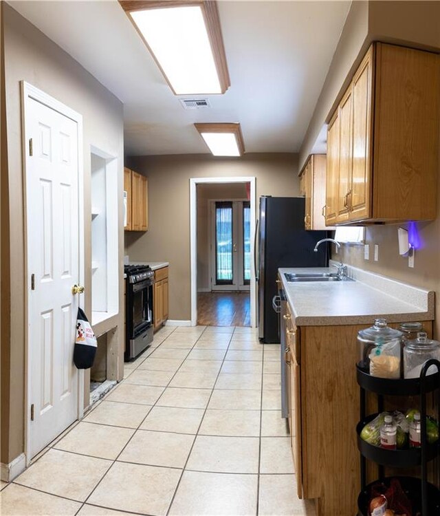 kitchen with sink, stove, and light hardwood / wood-style floors