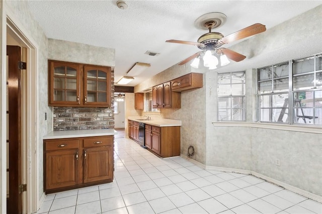 kitchen with black dishwasher, light tile patterned floors, ceiling fan, and a wealth of natural light