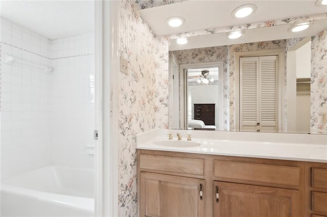 bathroom with tub / shower combination, vanity, and ceiling fan