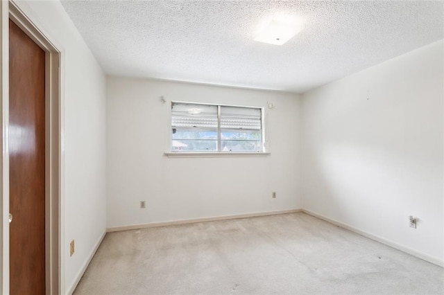 carpeted empty room with a textured ceiling