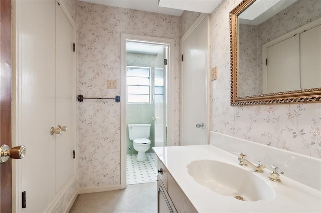 bathroom with toilet, tile patterned floors, and vanity