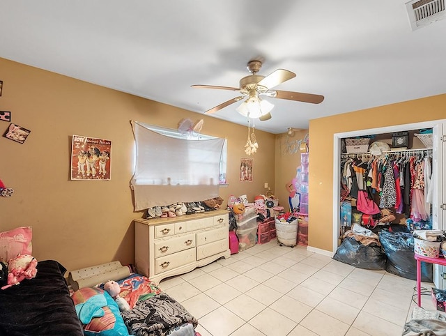 tiled bedroom featuring ceiling fan and a closet