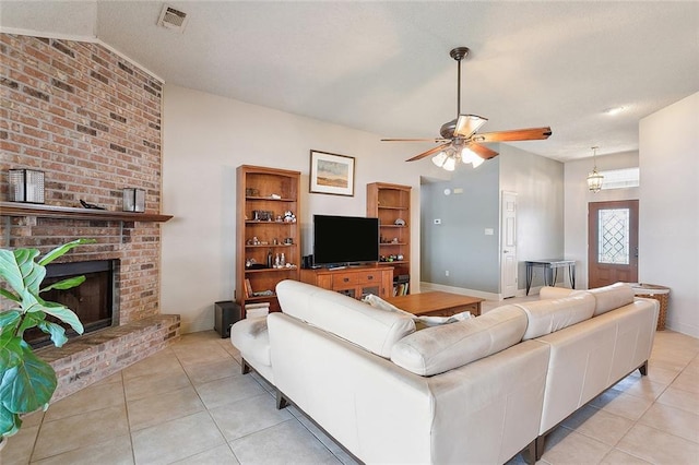 tiled living room with brick wall, a fireplace, and ceiling fan