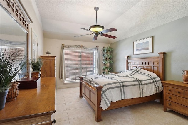 tiled bedroom featuring ceiling fan, a textured ceiling, and lofted ceiling