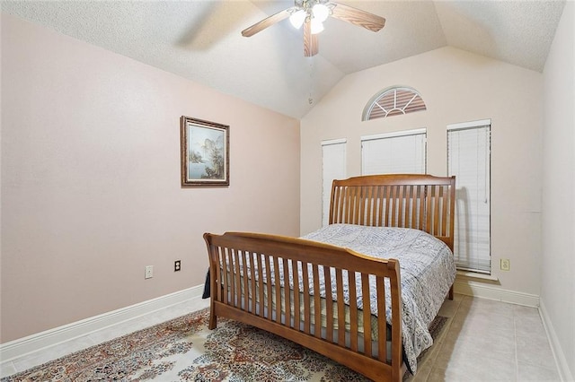 tiled bedroom featuring ceiling fan, vaulted ceiling, and a textured ceiling