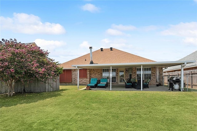 rear view of house with a patio and a lawn