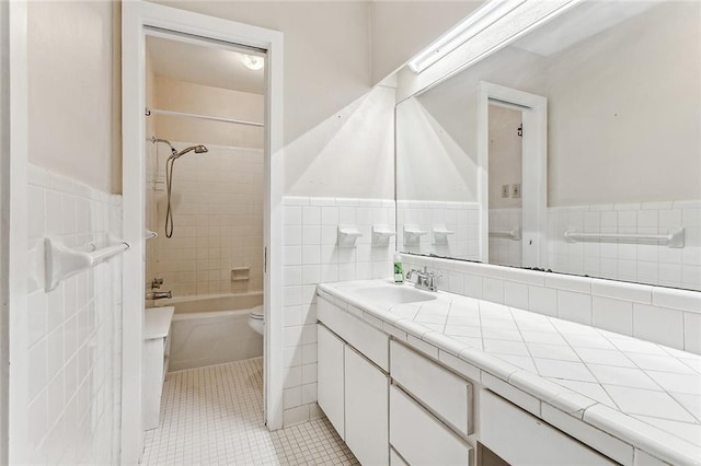 full bathroom with tile patterned flooring, vanity, toilet, and tile walls