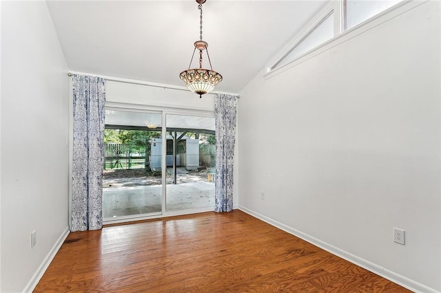 unfurnished room featuring wood-type flooring and vaulted ceiling