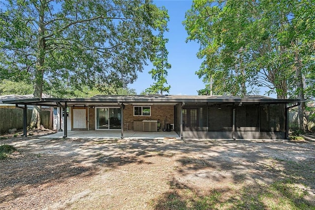 back of property with a sunroom and a patio area