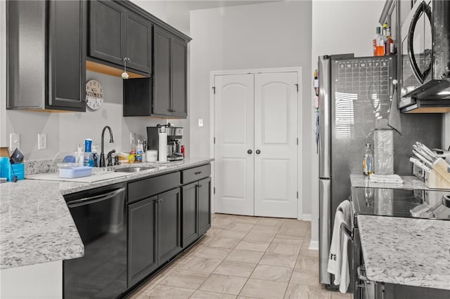 kitchen with dishwasher, light stone countertops, stove, light tile patterned floors, and sink