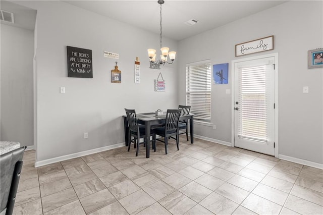 tiled dining room featuring an inviting chandelier