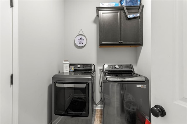 laundry room with washer and dryer and cabinets