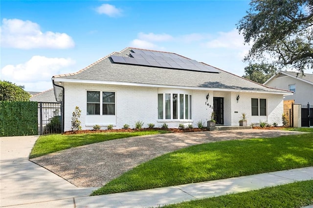 exterior space featuring a front lawn and solar panels