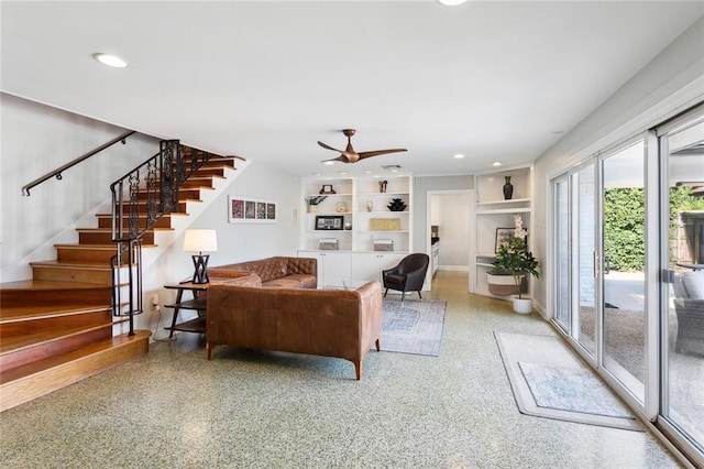 living room with ceiling fan and built in shelves