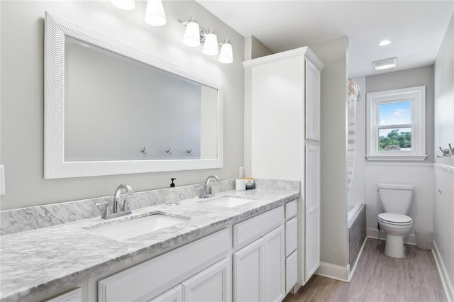 full bathroom featuring  shower combination, hardwood / wood-style floors, dual vanity, and toilet