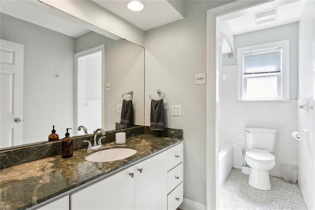 full bathroom with tile walls, bathtub / shower combination, toilet, and vanity