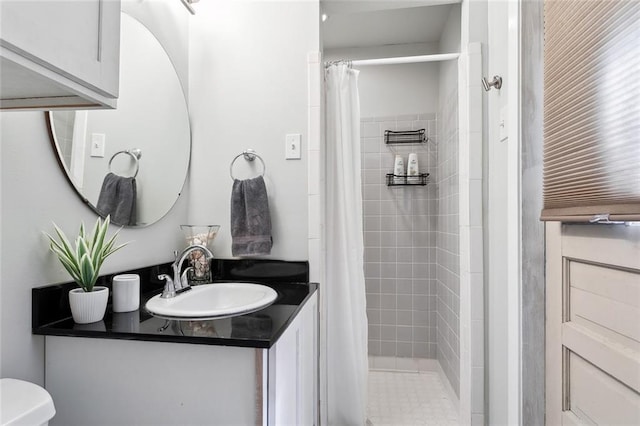 bathroom featuring vanity, walk in shower, and toilet