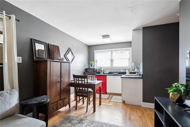 kitchen with white cabinets, sink, and light hardwood / wood-style floors