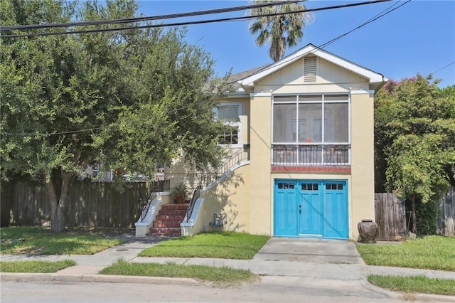 3722 Nashville Ave, New Orleans, LA 70125 - view of front of house featuring stucco siding, a sunroom, fence, and stairs