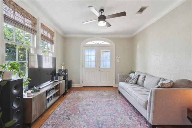 3722 Nashville Ave, New Orleans, LA 70125 - living room featuring light wood-type flooring, ornamental molding, a textured ceiling, and ceiling fan