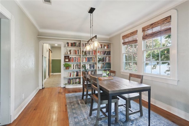 dining room with wood-type flooring and ornamental molding