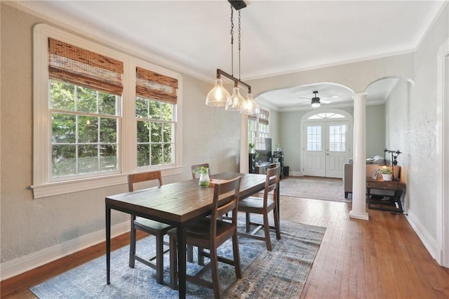 dining space with ornamental molding, ornate columns, hardwood / wood-style floors, and ceiling fan