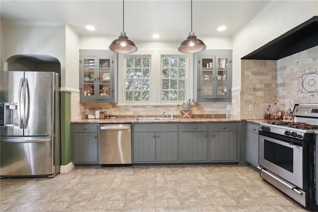 kitchen featuring tasteful backsplash, light tile patterned flooring, stainless steel appliances, hanging light fixtures, and gray cabinetry