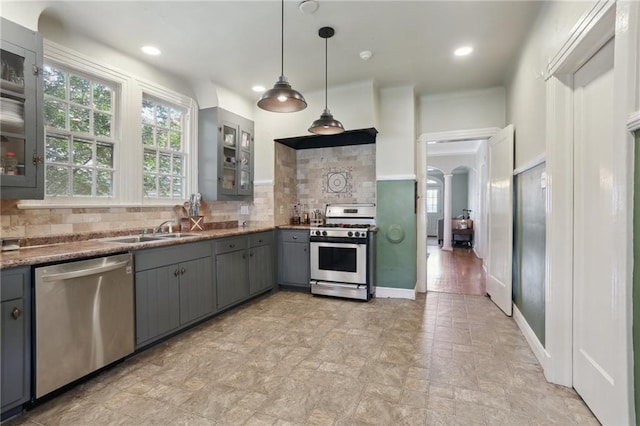 3722 Nashville Ave, New Orleans, LA 70125 - kitchen featuring arched walkways, a sink, decorative backsplash, gray cabinets, and appliances with stainless steel finishes