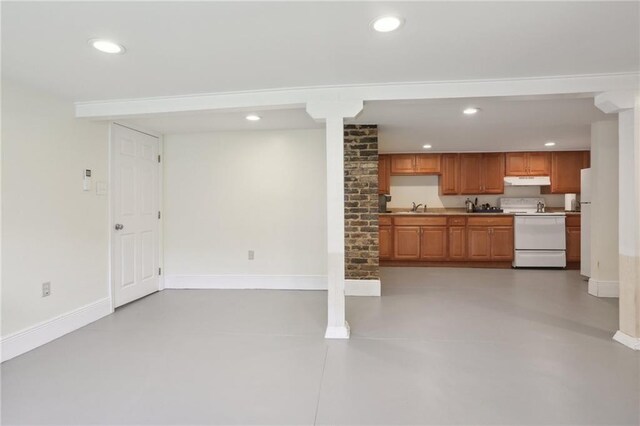 unfurnished living room with sink, ornate columns, and brick wall