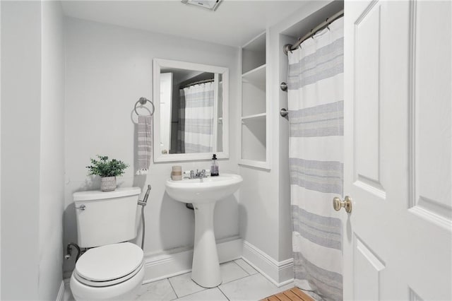 bathroom with toilet and tile patterned floors