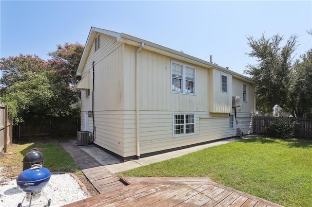 view of home's exterior featuring cooling unit, a wooden deck, and a lawn