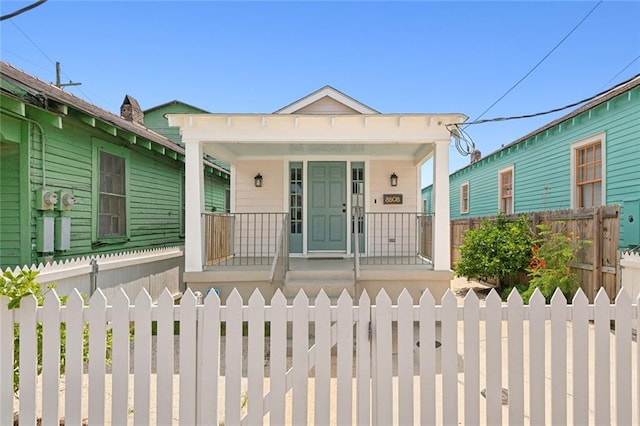 view of front facade featuring covered porch and a fenced front yard