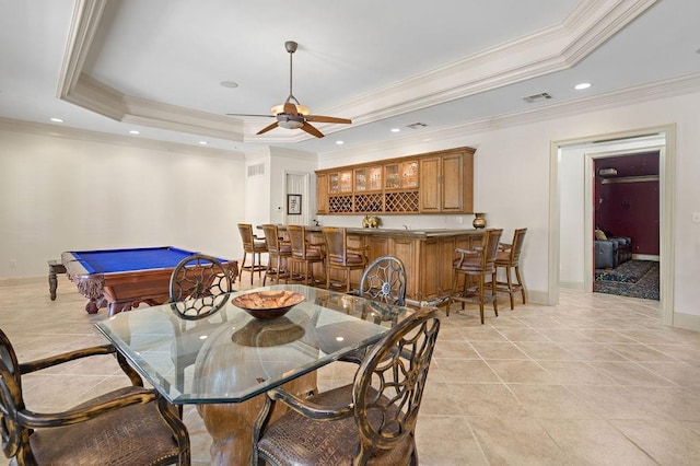 dining room with wet bar, a raised ceiling, recessed lighting, and baseboards