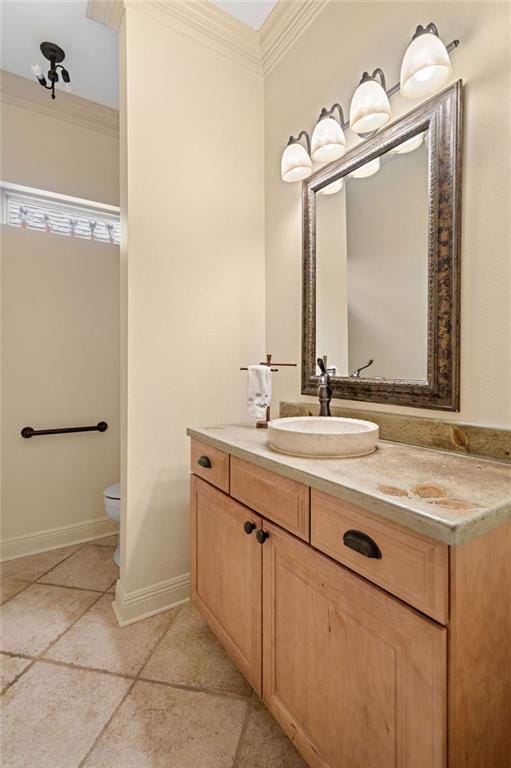 bathroom with vanity, toilet, baseboards, and ornamental molding