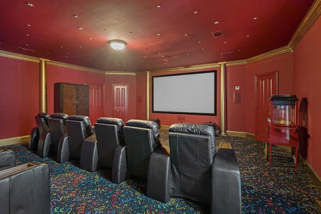 carpeted home theater room with visible vents, crown molding, and baseboards