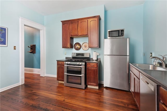 kitchen featuring appliances with stainless steel finishes, dark wood-type flooring, and sink