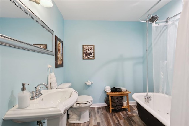 full bathroom featuring sink, hardwood / wood-style flooring, toilet, and shower / bath combo with shower curtain