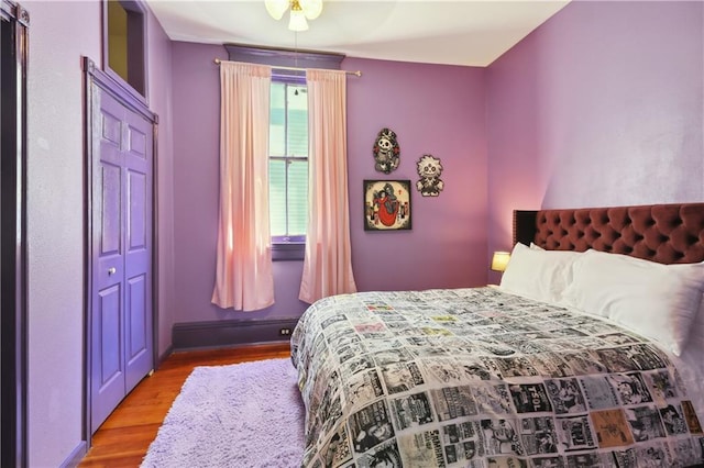 bedroom with a baseboard heating unit, light hardwood / wood-style flooring, and ceiling fan