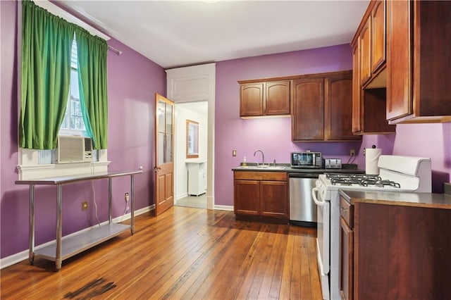 kitchen featuring appliances with stainless steel finishes, sink, and hardwood / wood-style flooring