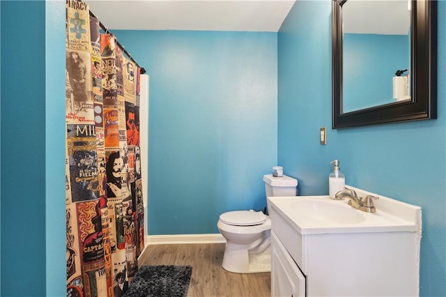 bathroom with hardwood / wood-style flooring, vanity, and toilet