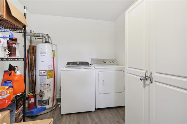 laundry area with water heater, washer and dryer, and hardwood / wood-style floors