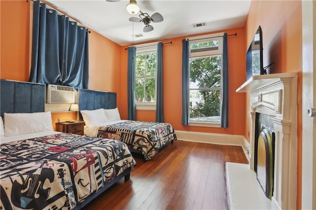 bedroom with cooling unit, dark hardwood / wood-style flooring, and ceiling fan