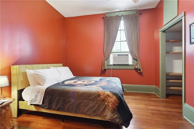 bedroom with cooling unit and hardwood / wood-style floors