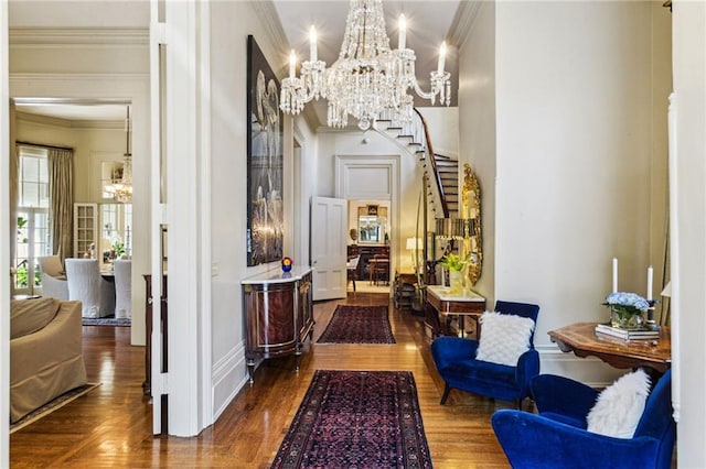 hall featuring ornamental molding, dark wood-type flooring, and an inviting chandelier