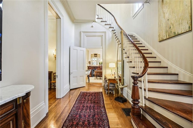 foyer featuring light hardwood / wood-style flooring and ornamental molding